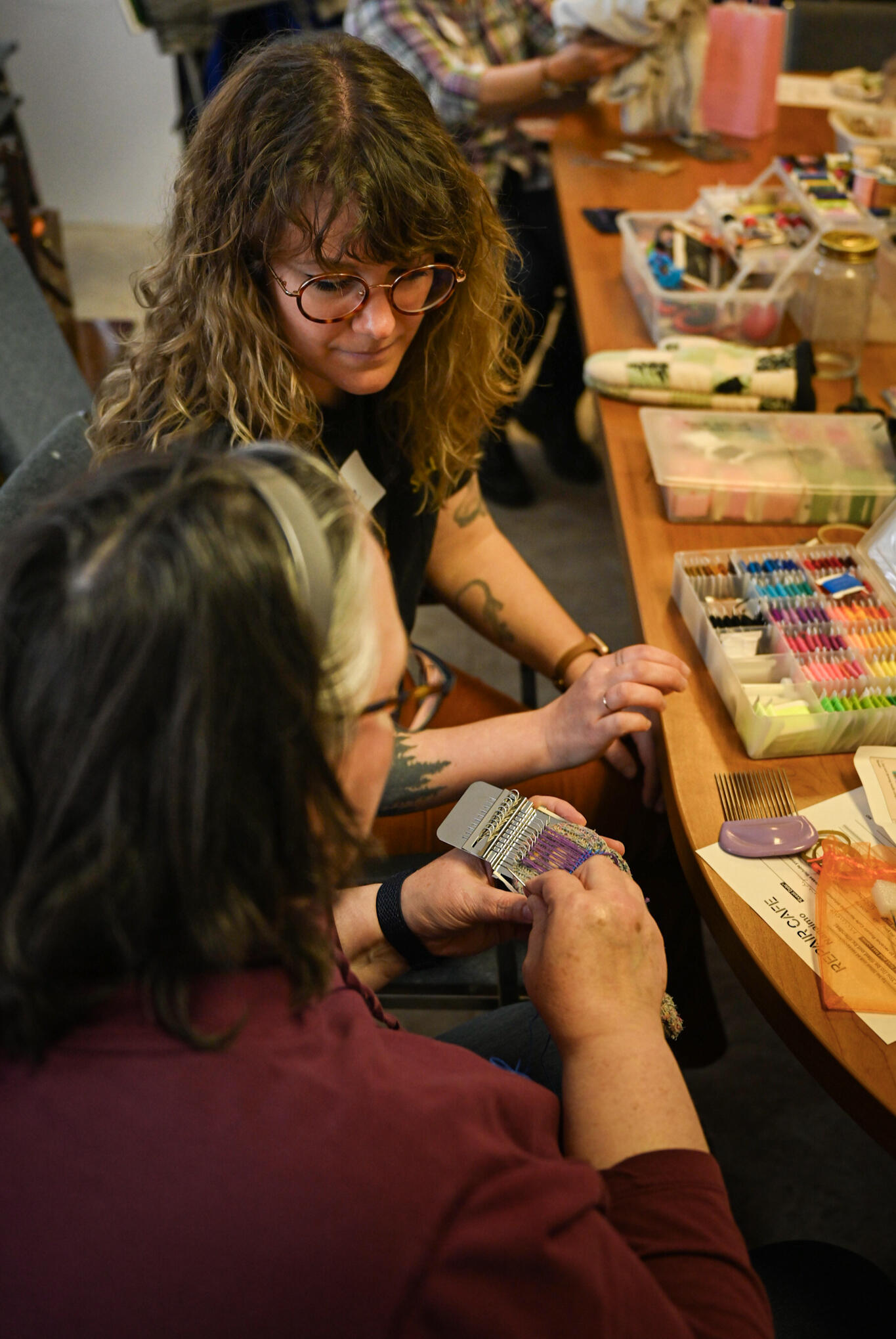 Volunteer interacting with attendee showing them the basics of textiles.